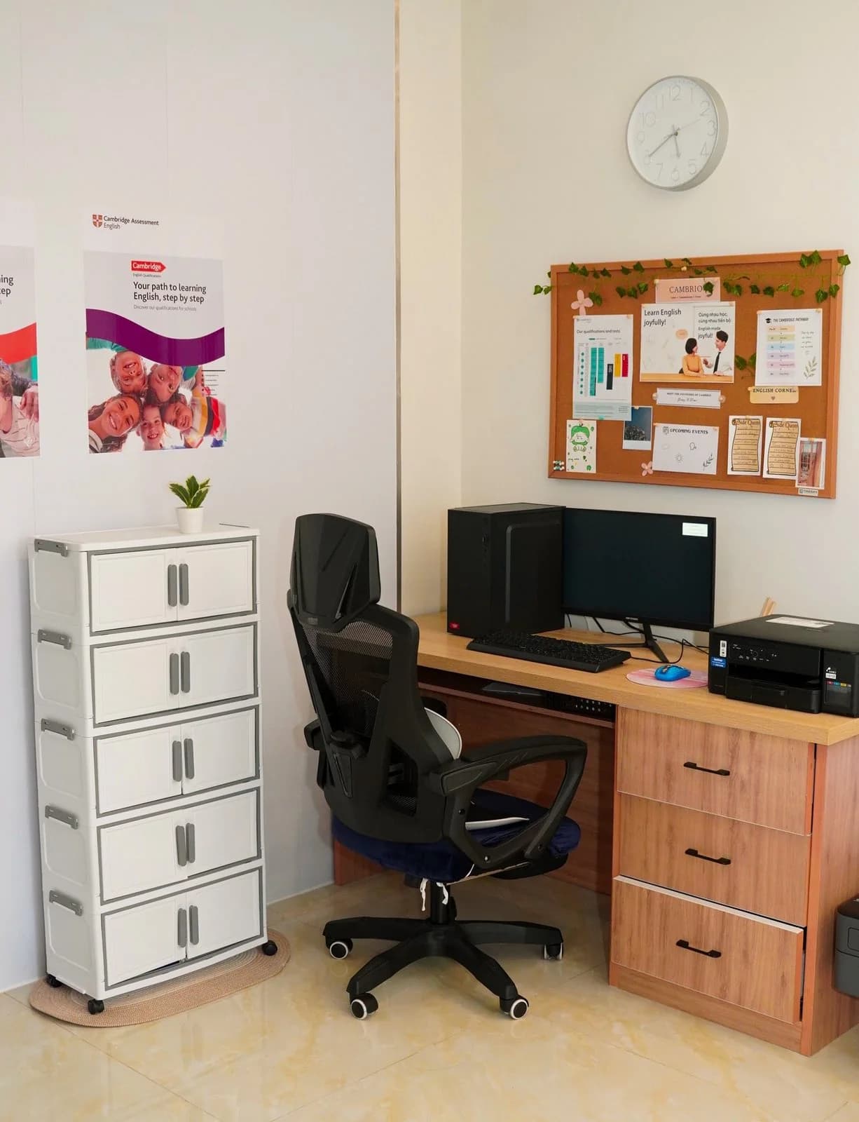 Staff desk with computer and the Cambrio 'English Corner' pinboard of learning materials